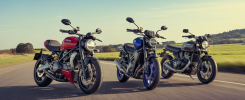 Comparatif 2025 de motos naked : Ducati Streetfighter V2 S rouge, Yamaha MT-09 SP bleu et Triumph Street Triple 765 RS gris sur route sinueuse