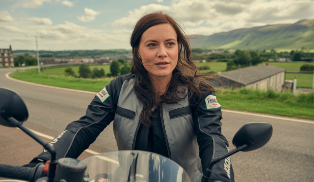 Noraly Schuurmans alias Itchy Boots en moto lors de sa tournée de 3400 miles au Royaume-Uni, en interaction avec des fans à cinq événements, capturée dans une série YouTube dédiée à l'aventure moto