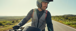 Motard en équipement respirant sur une route ensoleillée